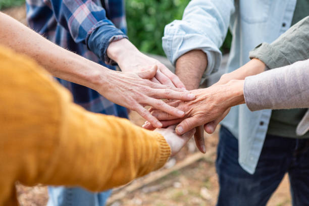 Unrecognizable multiracial group of people put their hands into the circle in unity