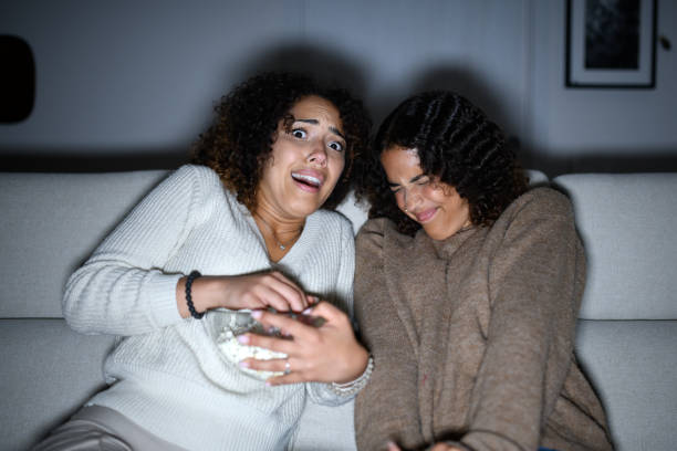istock Sisters watching TV on sofa: Scary movie 2161190630