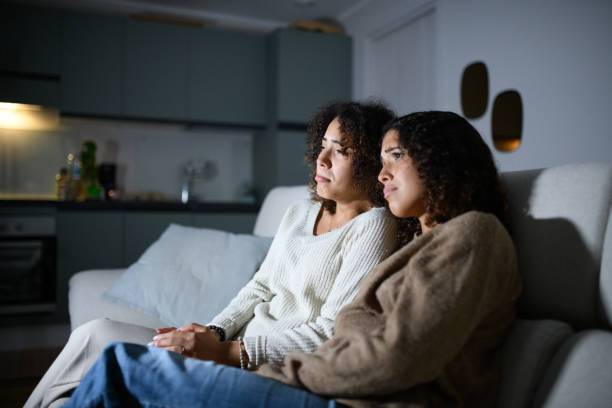istock Sisters watching TV on sofa: Sad romantic movie 2161190907