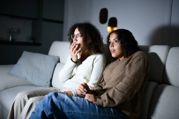 istock Sisters watching TV on sofa: Scary movie 2161190949