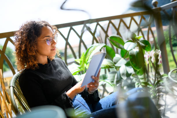 istock Woman reading book on the balcony 2161192299