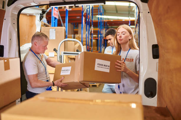 istock volunteers loading food parcels into the van 2161194632