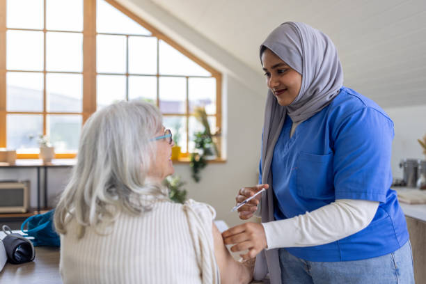 istock Nurse vaccinating elderly woman 2161201598