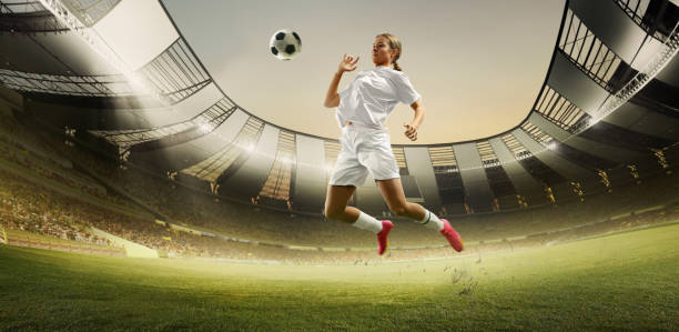 istock Horizontal image banner with young determined athlete, girl, soccer player in motion, action, hitting ball with chest. 3D render of stadium with flashlights and fan tribune 2161202607