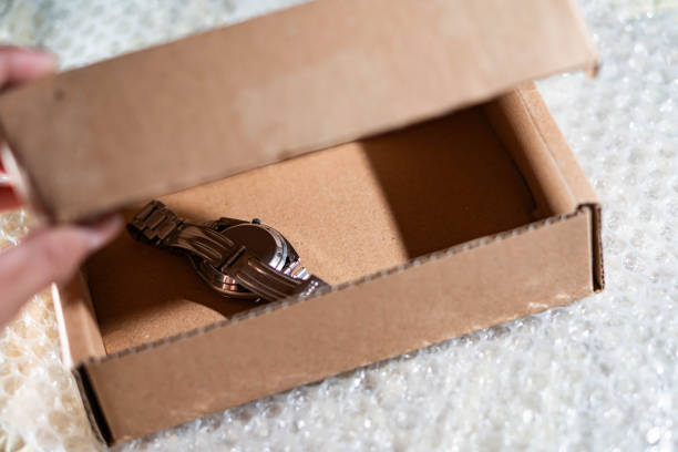 istock Opening a cardboard box with a wristwatch inside 2161202851