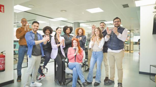 istock Group of diverse office employees clapping and smiling in modern office. 2161204220