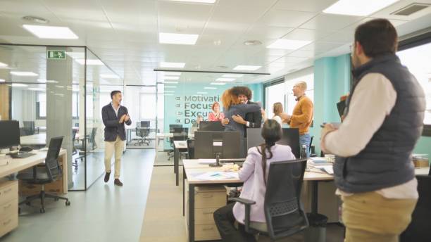 istock Office employees celebrating a work achievement with hugs and applause. 2161204321