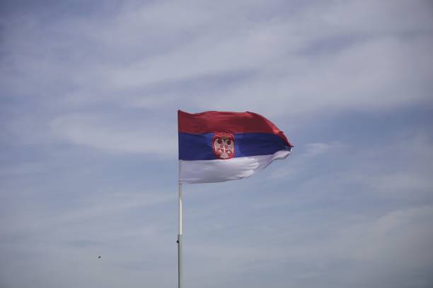 istock Serbian flag waving against a partly cloudy sky 2161204616