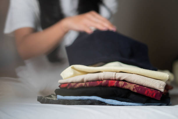 istock Person folding clothes on a bed 2161205165