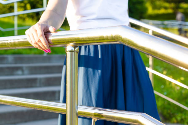 istock woman's hand holding onto the metal staircase railing. 2161211310