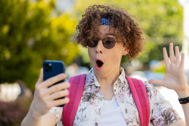 istock Tourist man using mobile smartphone celebrating win receive good message news wow emotion outdoors 2161214121