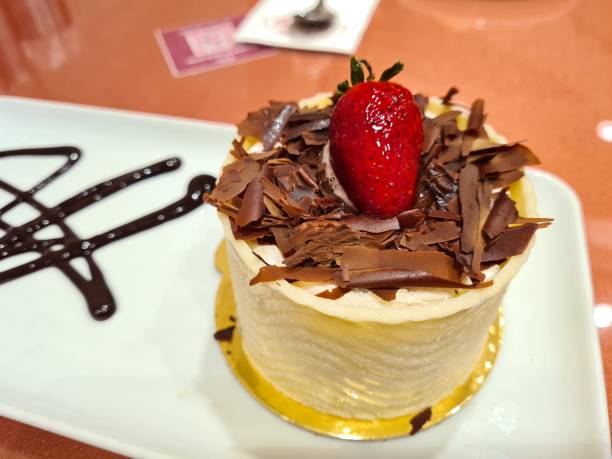 A single serving chocolate cake, topped with a strawberry, chocolate shavings