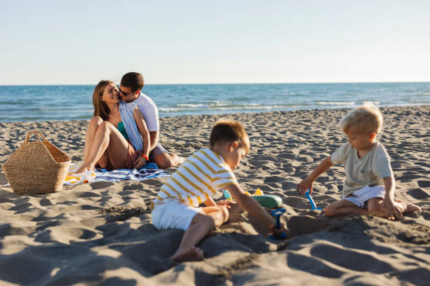 istock Family Relaxing and Playing on the Beach 2161217823