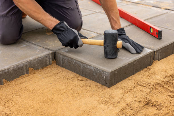 istock worker installing concrete paving slabs on sand foundation 2161221828