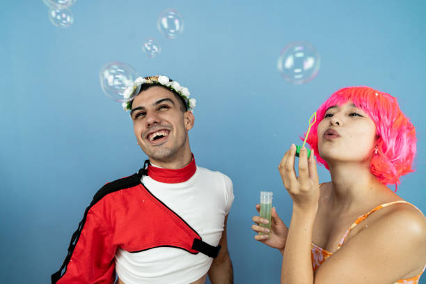 Friends having fun with soap bubble on a blue background