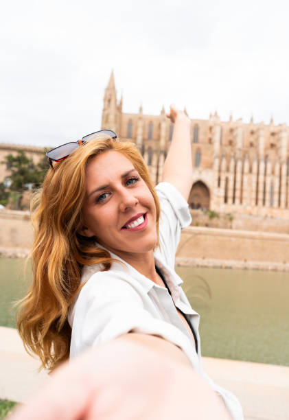 istock Woman in sunglasses gesturing happily while taking a selfie visiting a city 2161224434