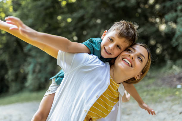 istock Young beautiful mother playing with her son piggy back. 2161225566