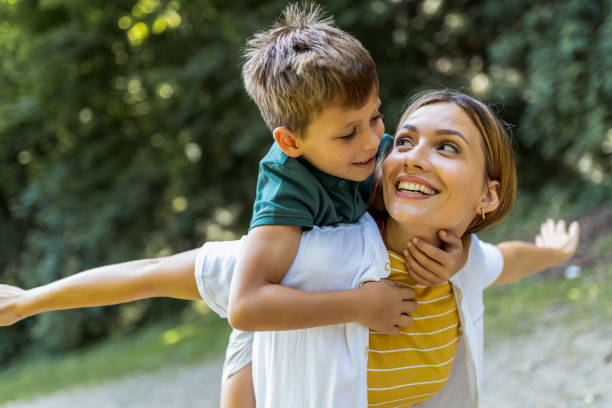 istock Young beautiful mother playing with her son piggy back. 2161225568