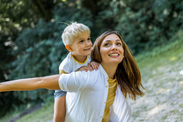 istock Young beautiful mother playing with her son piggy back. 2161226154