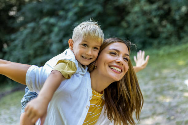 istock Young beautiful mother playing with her son piggy back. 2161226162