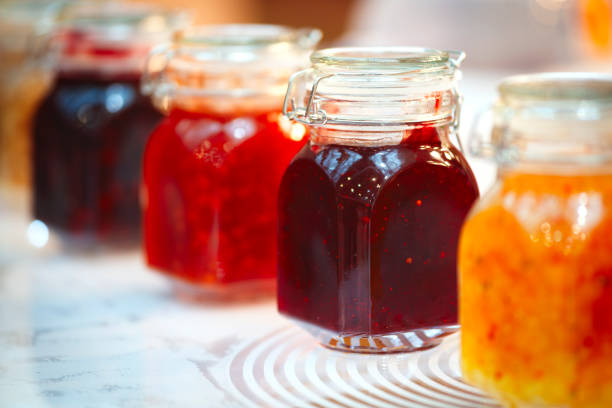 istock A row of jars with different colored jams. The jars are lined up on a table 2161227189