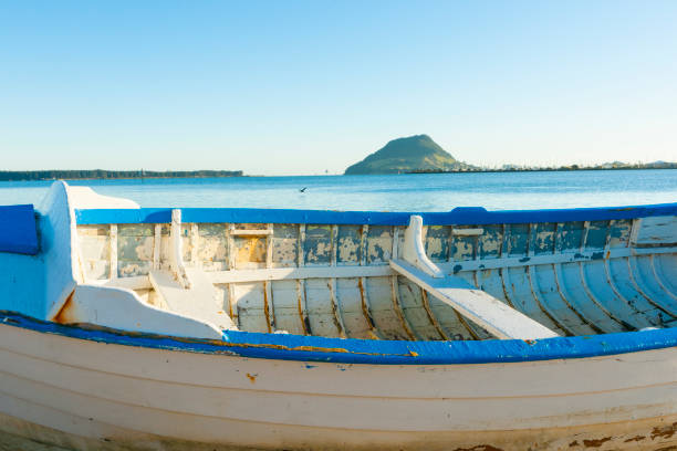 A small rowboat gently floats in the calm waters of Arrecife’s harbor on Lanzarote. Painted in green and white, it stands out against the crystal-clear, shallow sea, where you can easily spot the rocky seabed. Soft ripples surround the boat as it rests near the dock, giving off peaceful, laid-back island vibes. It’s the perfect snapshot of Lanzarote’s easygoing coastal charm, where life slows down and the ocean does all the talking.