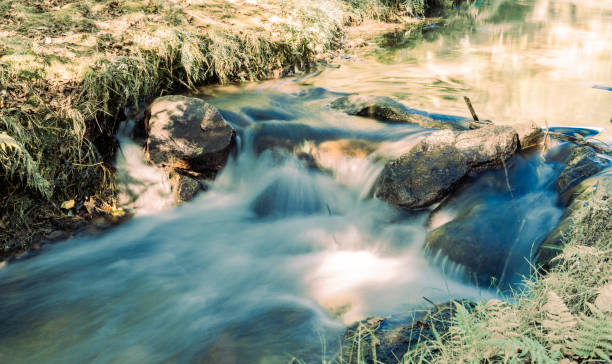 Faded old image effect white water tumbling over rocky drop in stream in McLaren Falls Park Tauranga,