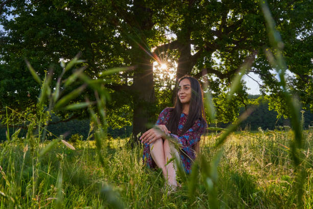 Gorgeous hispanic young woman on a meadow with oak forest