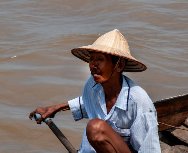 Vietnamese man catching fishes in Mekong River Delta, South Vietnam