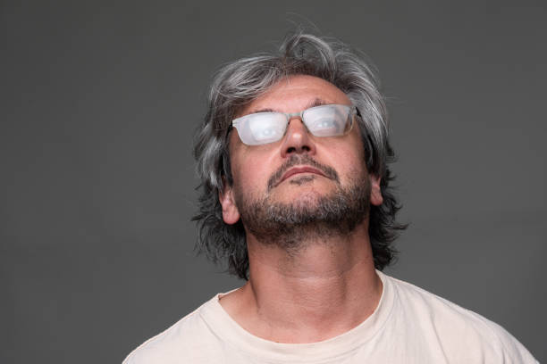 Portrait Headshot of a Caucasian Mature man looking up on  gray background