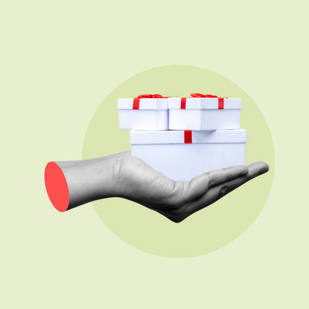 istock Hand holding stack of white gift boxes with red ribbon on green background 2161259081