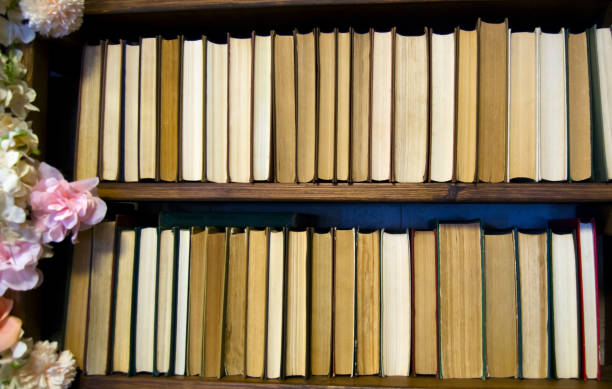 Old books on wooden shelf in library.