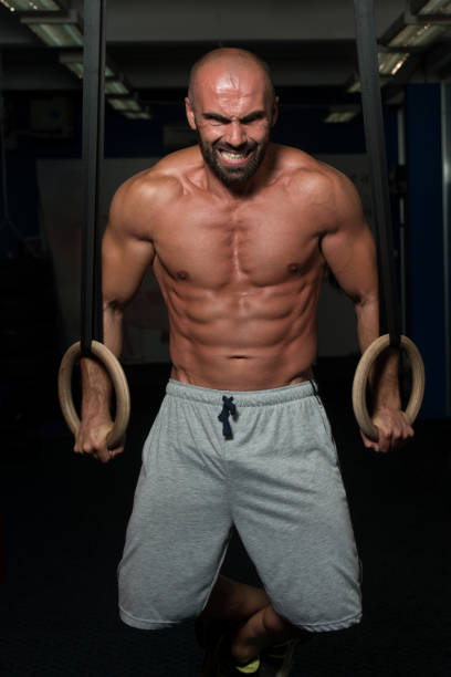Adult Man Exercising While Holding Large Gymnastic Rings At The Gym