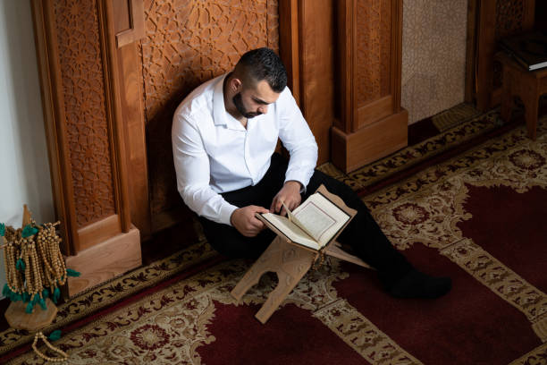 istock Muslim Man Reading Holy Islamic Book Koran 2161261098