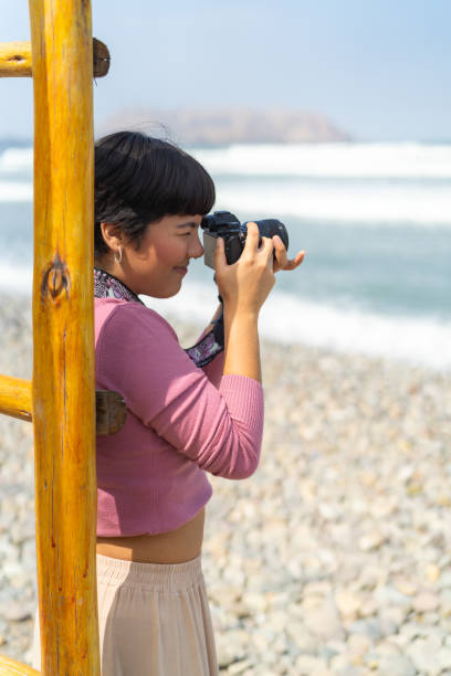 istock Young photographer taking photos on the beach 2161265269