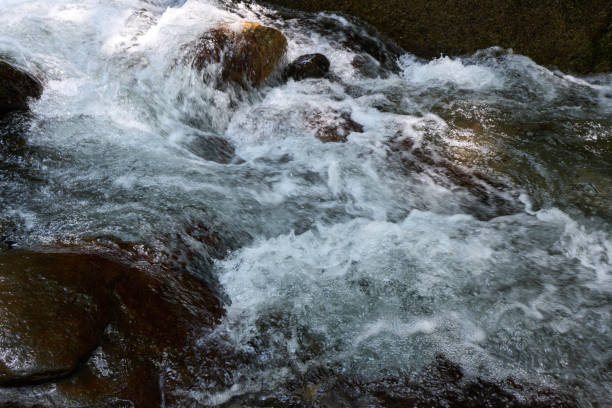 istock [Shinshiro] Splashing water from a mountain stream flowing over rocks 2161265777