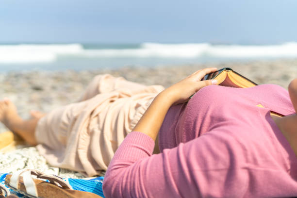 Close-up photo of a unrecognizable latin woman taking a break from reading on the beach