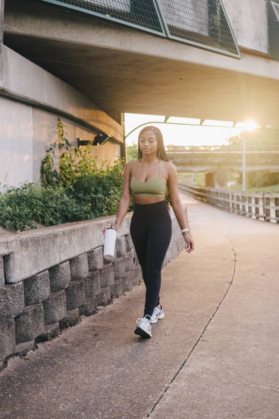 istock Young woman taking an evening walk through a public park 2161272808
