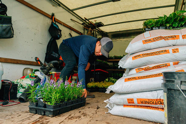 Nursery Delivery Worker Loading Flowers and Plants into a Box Truck