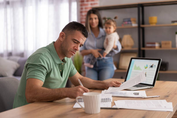 istock Man working with papers and laptop at home 2161280889