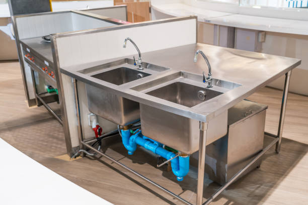 ห้องครัวมืออาชีพในสถานประกอบการจัดเลี้ยงดูเคาน์เตอร์สแตนเลส - การวางระบบการจัดการน้ำและน้ำเสียในครัวร้านอาหาร ภาพสต็อก ภาพถ่ายและรูปภาพปลอดค่าลิขสิทธิ์