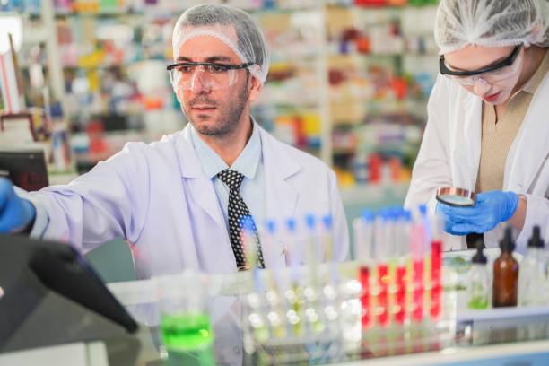 istock scientists perform experiments and record data. people arranges equipment with test tubes and chemicals for producing medicine and biochemistry. man hold tubes of chemical liquids and plant samples. 2161282402
