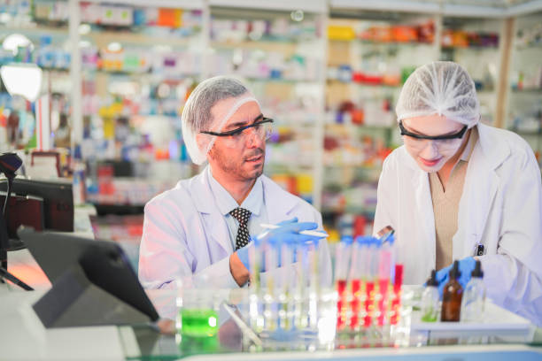istock scientists perform experiments and record data. people arranges equipment with test tubes and chemicals for producing medicine and biochemistry. man hold tubes of chemical liquids and plant samples. 2161282456