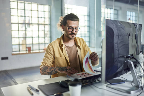 istock Young businessman working on reports at corporate office. 2161283783