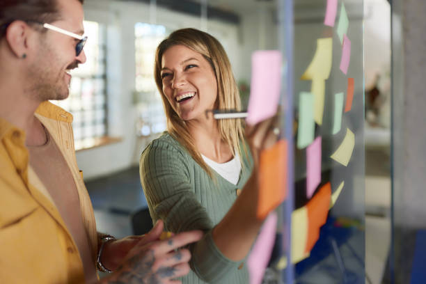 istock Happy creative colleagues making mind map on a glass wall in the office. 2161283870