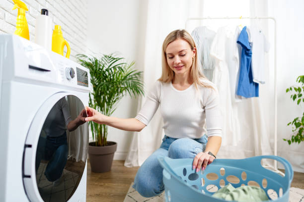 istock Woman Doing Laundry near a Washing Machine 2161287592