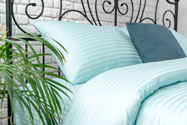 istock Mint Green Striped Bedding on a Black Metal Frame Bed 2161287601