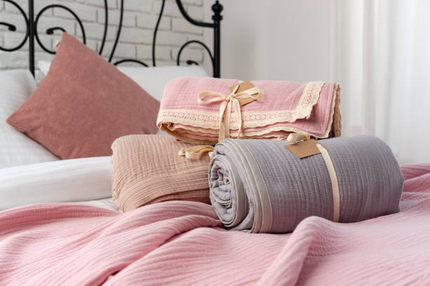 istock Rolled Up Soft Pink and Grey Muslin Blankets on Bed 2161289354