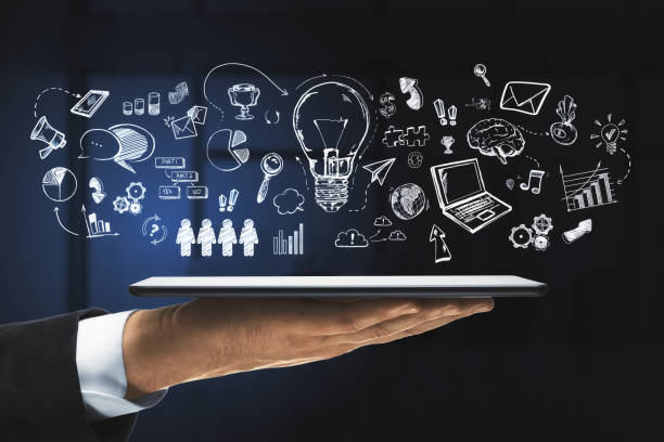 istock A hand holding a digital tablet with various drawn icons floating above it against a dark background, illustrating the concept of ideas and technology 2161293080