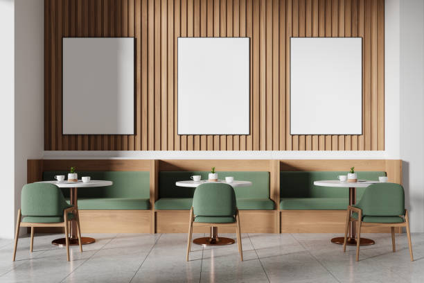 istock Modern cafe with green chairs, wooden wall panels, three empty frames, and white tables, light background. Cozy dining concept.  3D Rendering 2161293227